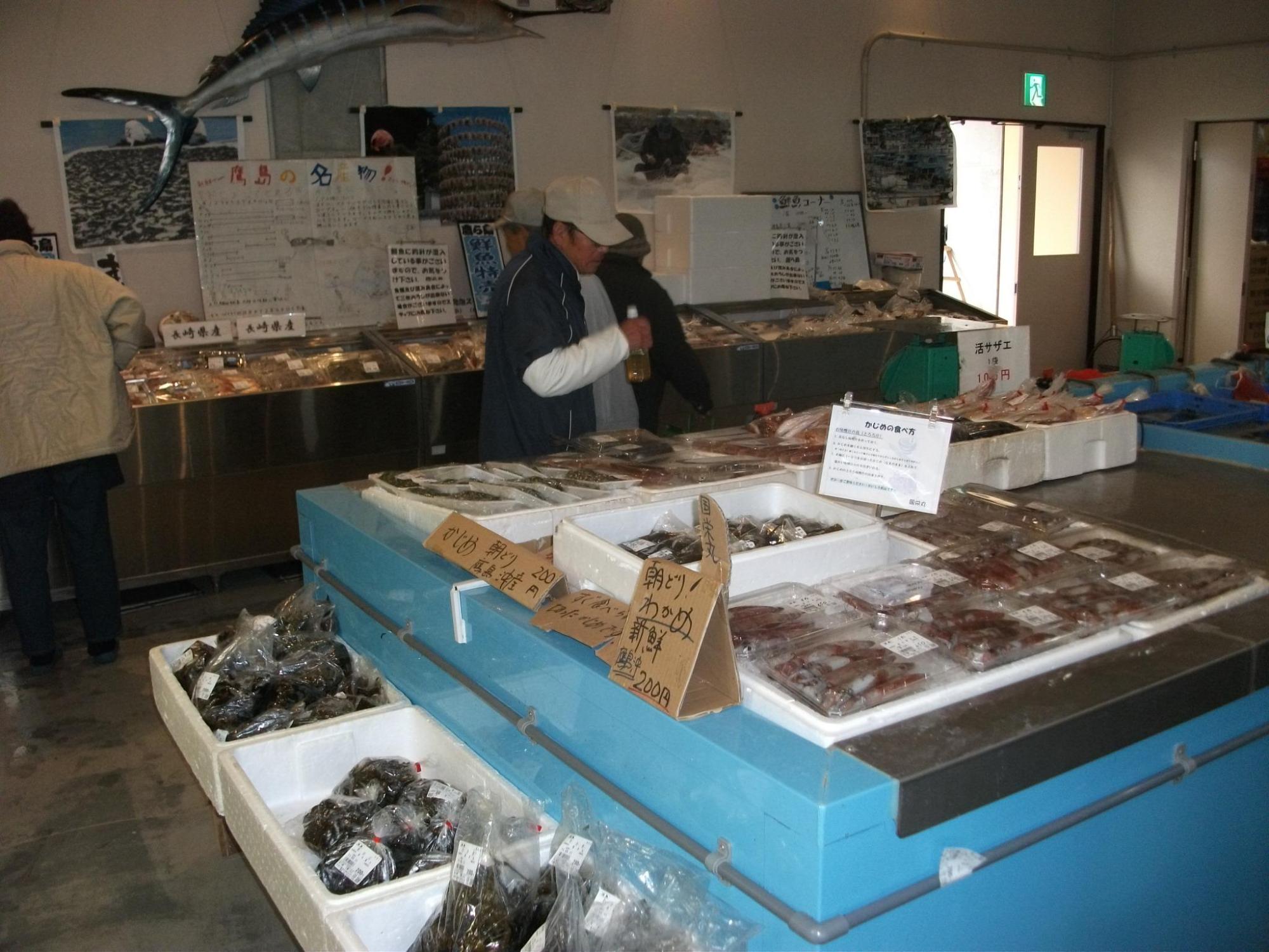 鮮魚コーナーで商品を選ぶお客さんの写真