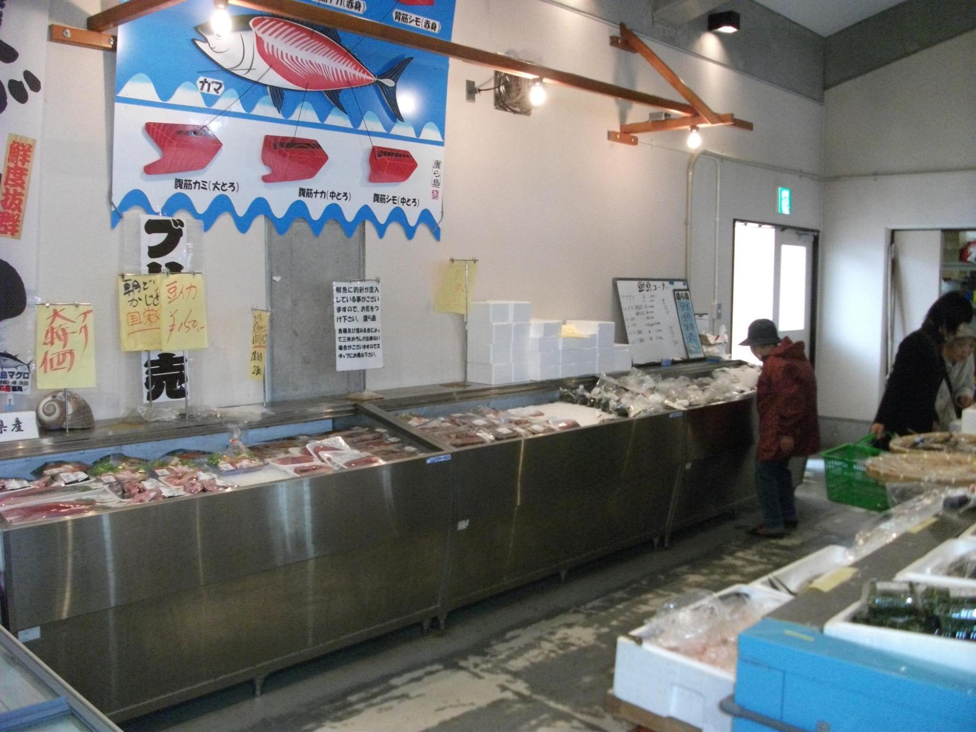 鮮魚コーナーで商品を選ぶお客さんの写真